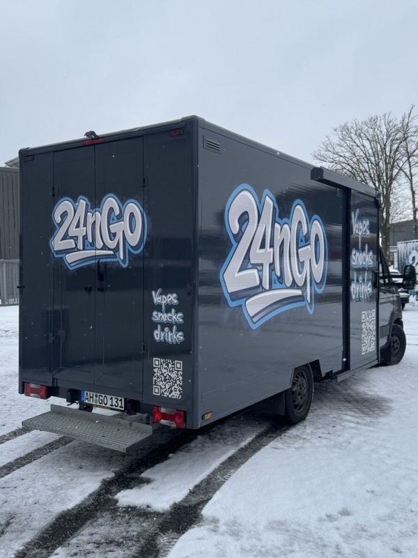 Schwarzer 24nGo-Transporter von hinten im Schnee, Schriftzug auf beiden Seiten