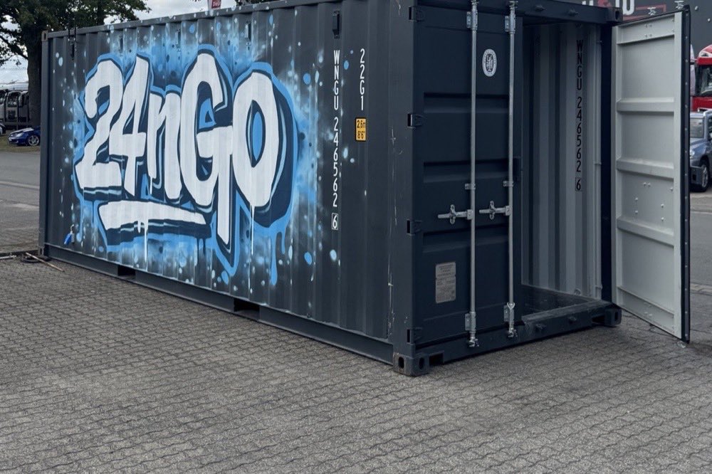 Blauer 24nGo-Container mit großem Graffiti-Schriftzug auf einem gepflasterten Platz