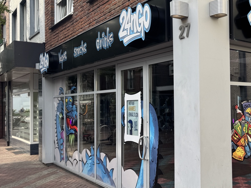 Der Store an der Wüllener Straße bei Tag: Ecklage, Graffiti-Drache auf der Scheibe, Hausnummer 27